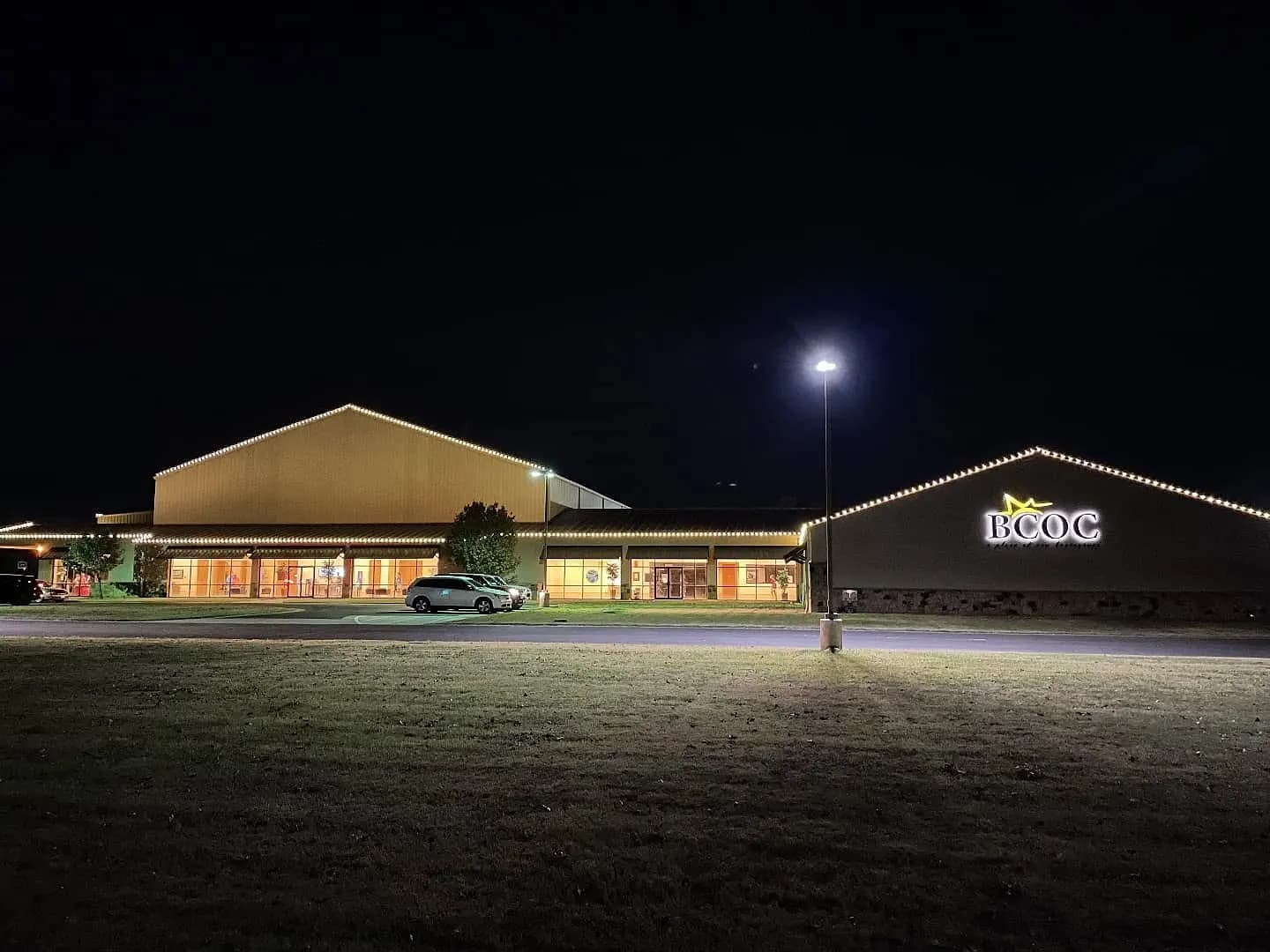 Commercial building with warm white lights along the roofline at night