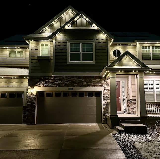 Two-story home with permanent warm white LED lights mounted along the eaves and gables